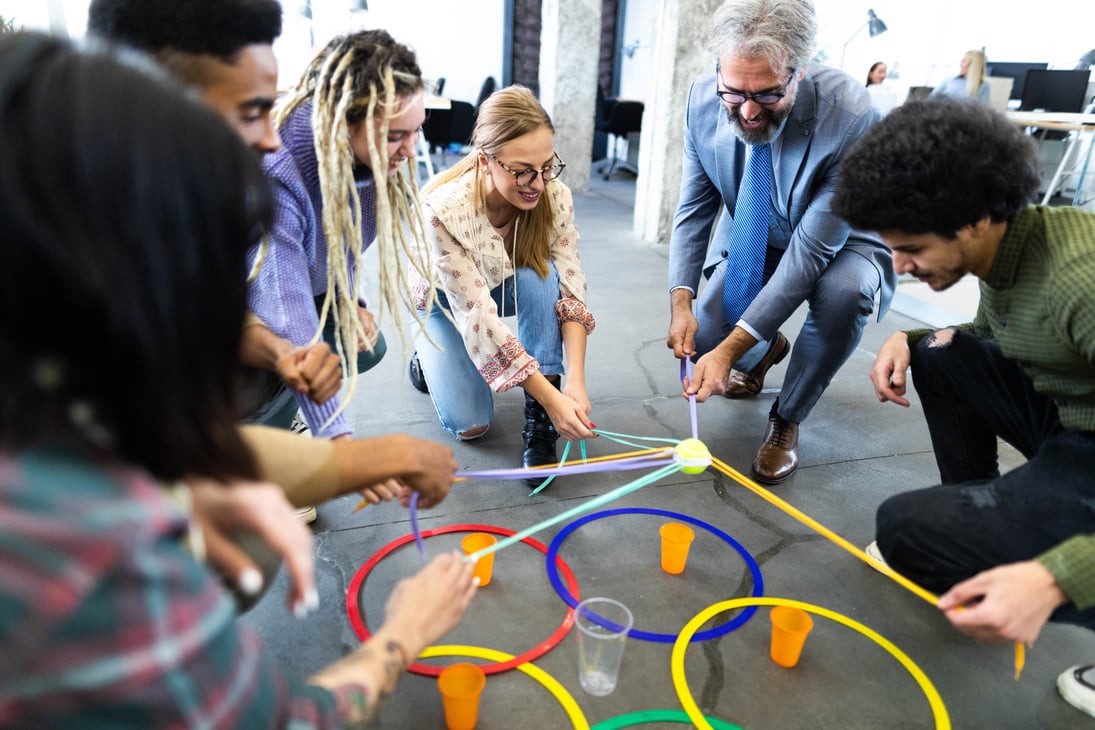 Happy creative colleagues playing team building games in the office.